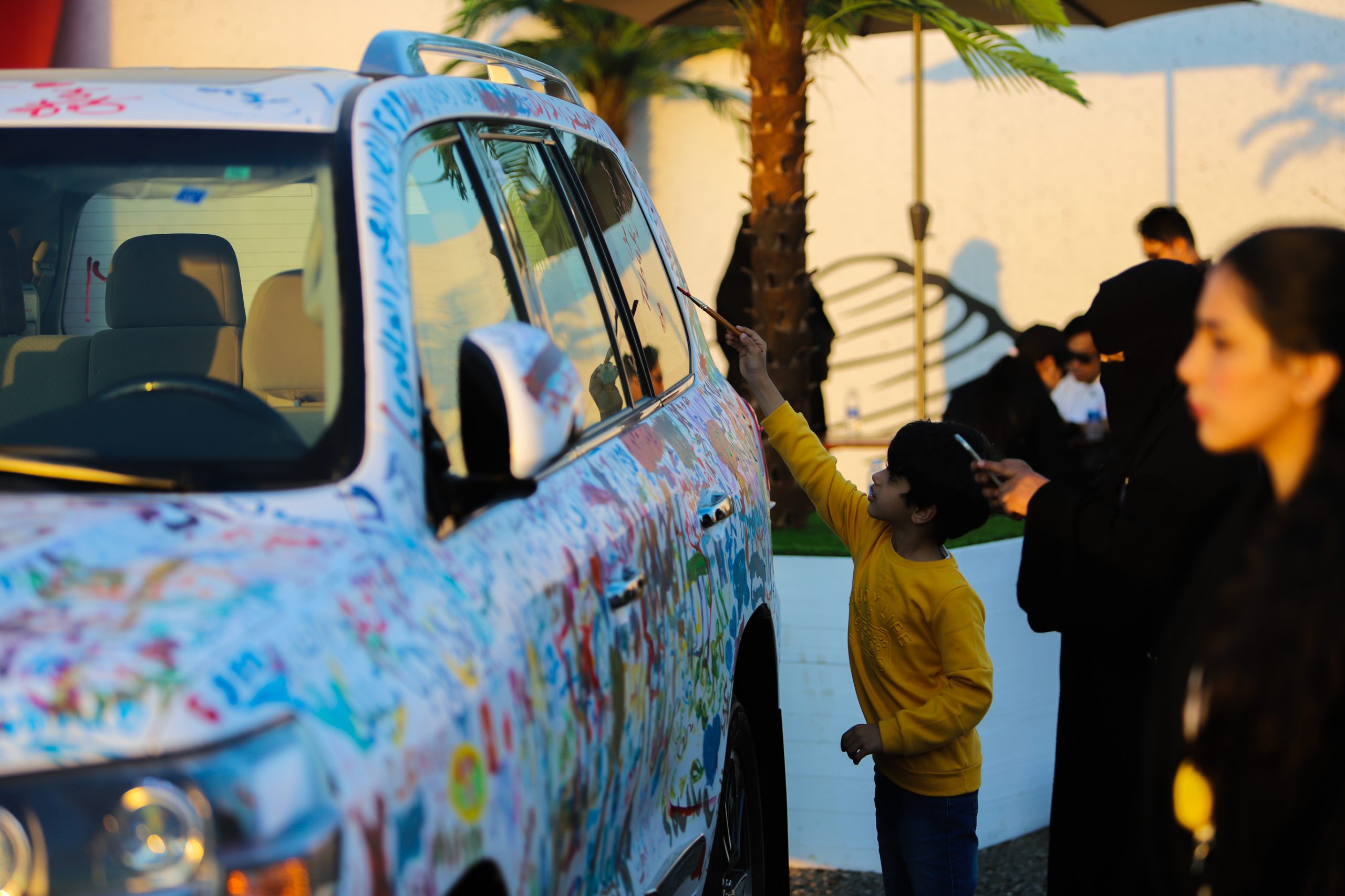 Event attendees were invited to memorialize their participation by writing their names and messages on a Land Cruiser car, in bright and colorful paint.